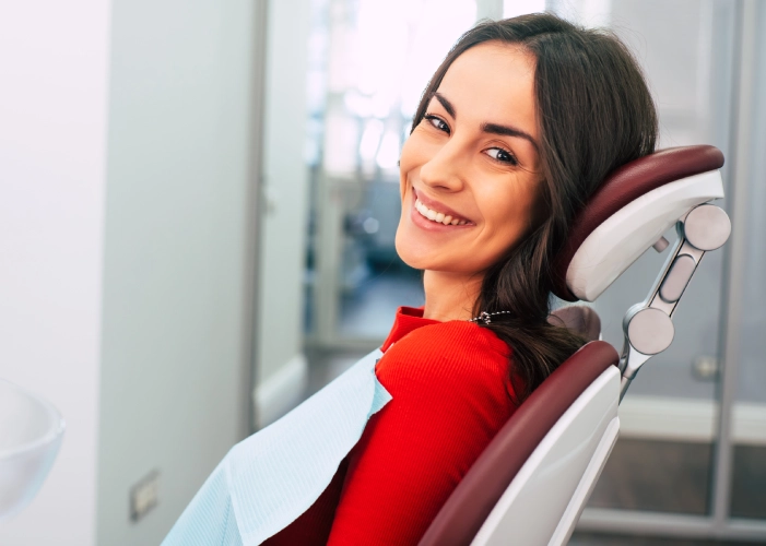 Woman in red shirt smiling in dental chair at Highland Dental Studio Phoenix