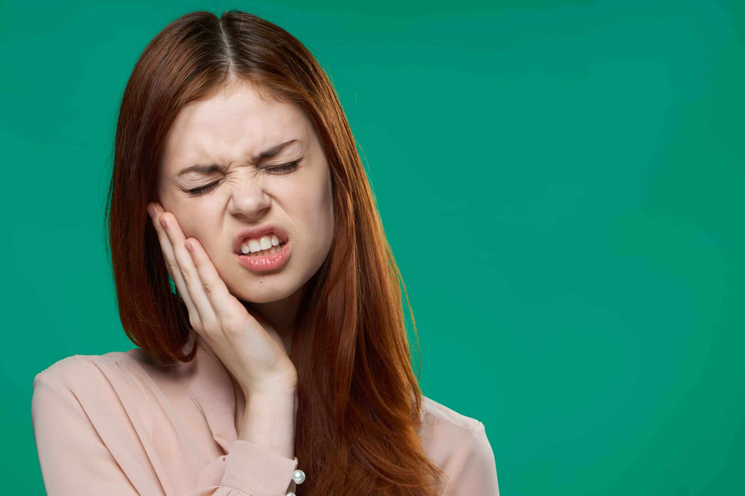 Person experiencing broken tooth pain at night in Phoenix needing emergency dental care