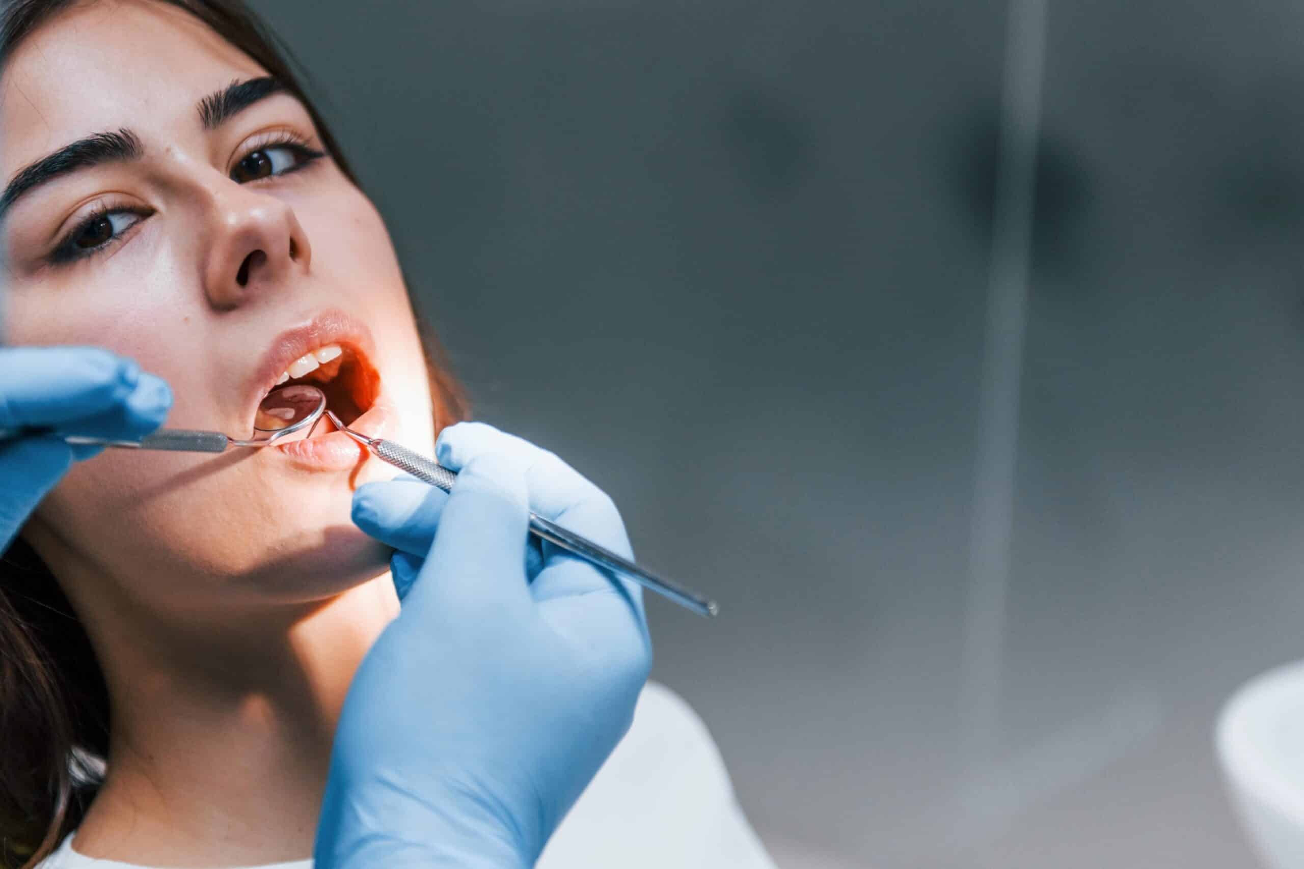 Dentist examining patient's teeth during dental implant consultation in Phoenix.